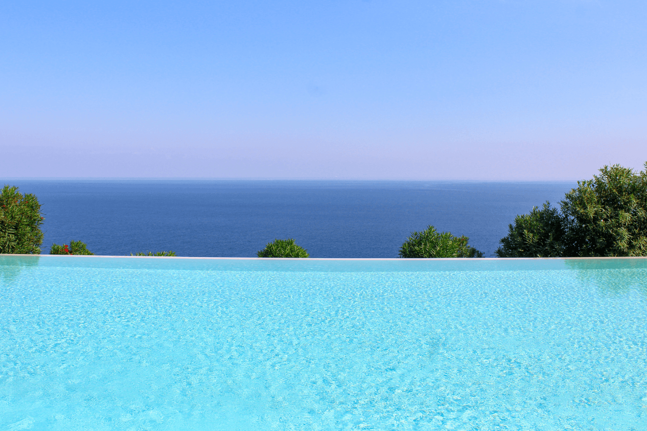 Minimalist infinity pool merging with the sea horizon — Costa del Sol and Costa de la Luz