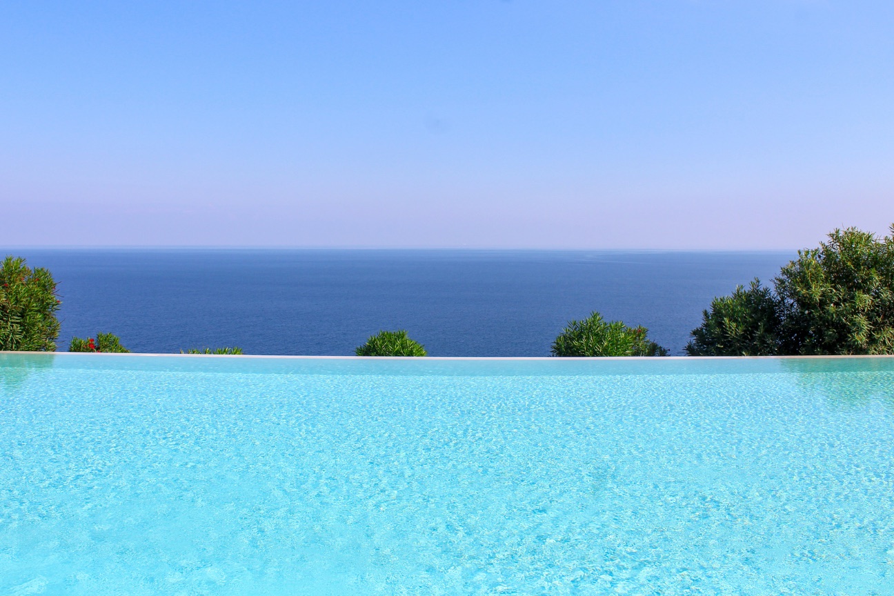 Minimalist infinity pool merging with the sea horizon — Costa del Sol and Costa de la Luz