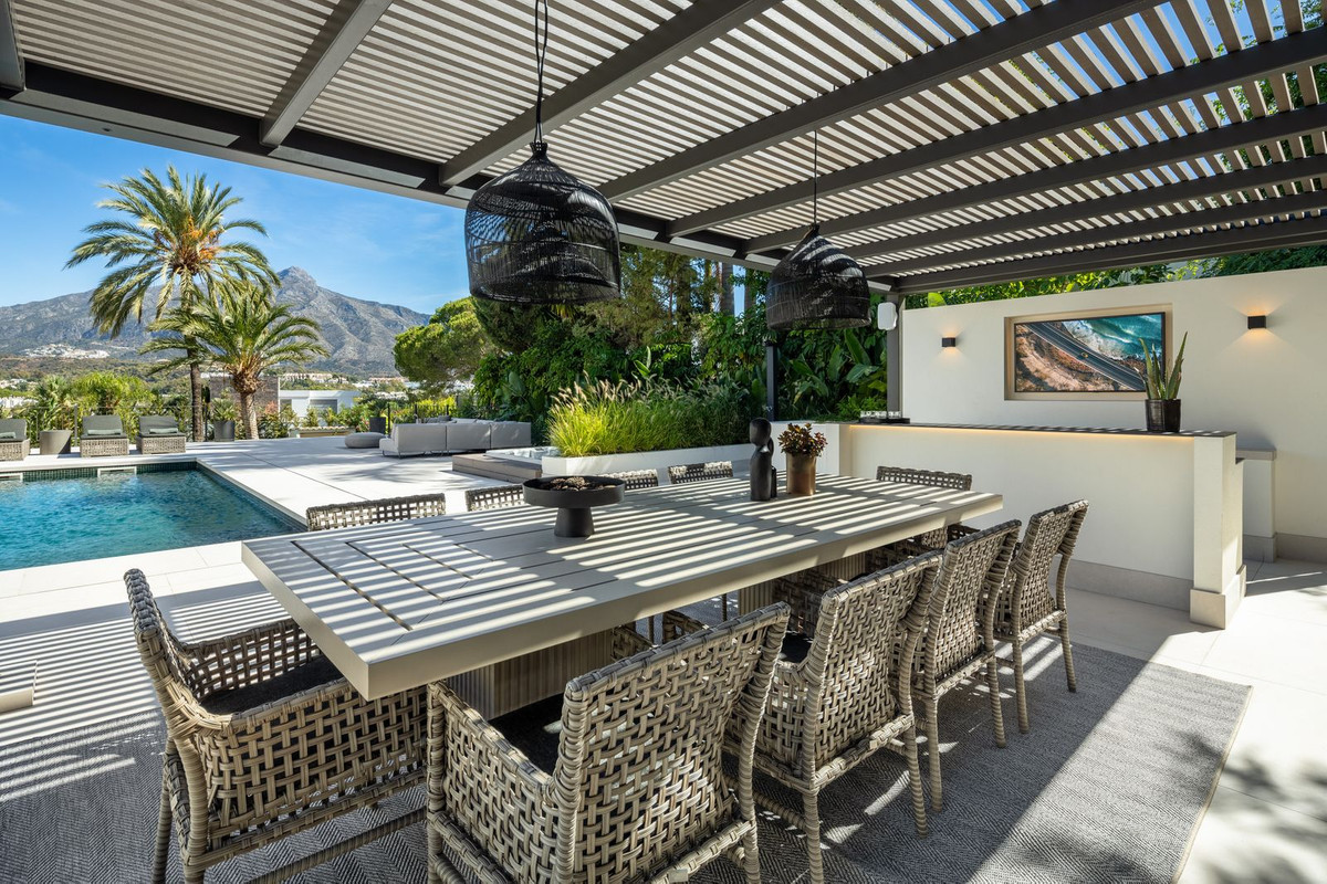 Outdoor dining terrace overlooking pool and La Concha mountain — authentic Marbella lifestyle