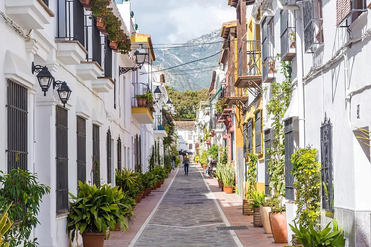 Narrow street in Marbella old town with white walls and flower pots — casco histórico, Costa del Sol