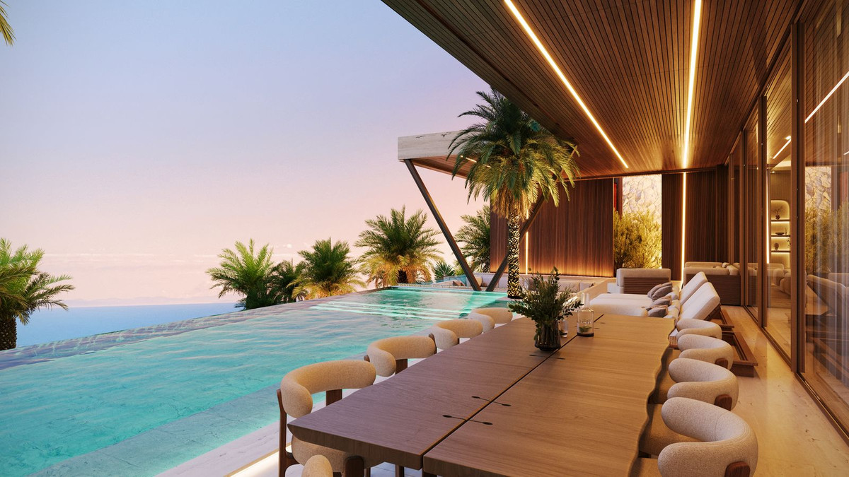 Outdoor dining table at infinity pool with sea views at sunset — dinner at a villa in Sierra Blanca, Marbella