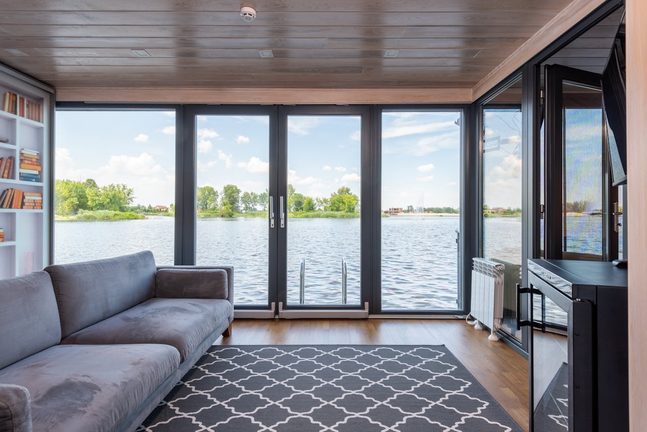 Luxury living room with floor-to-ceiling windows overlooking water — indoor-outdoor living, Costa del Sol