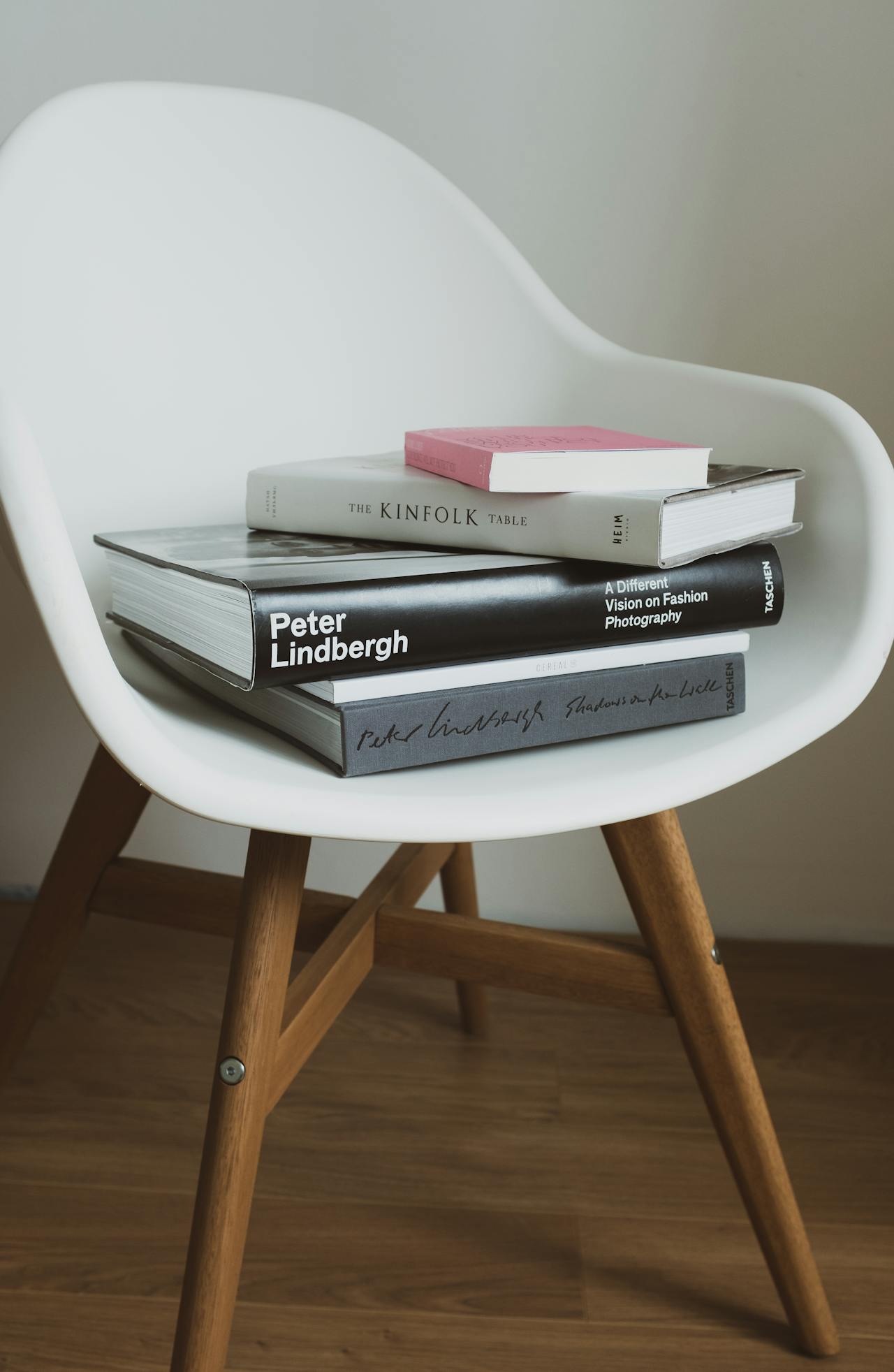 Designer chair with curated art books — design icons Eames Knoll Cassina luxury interior